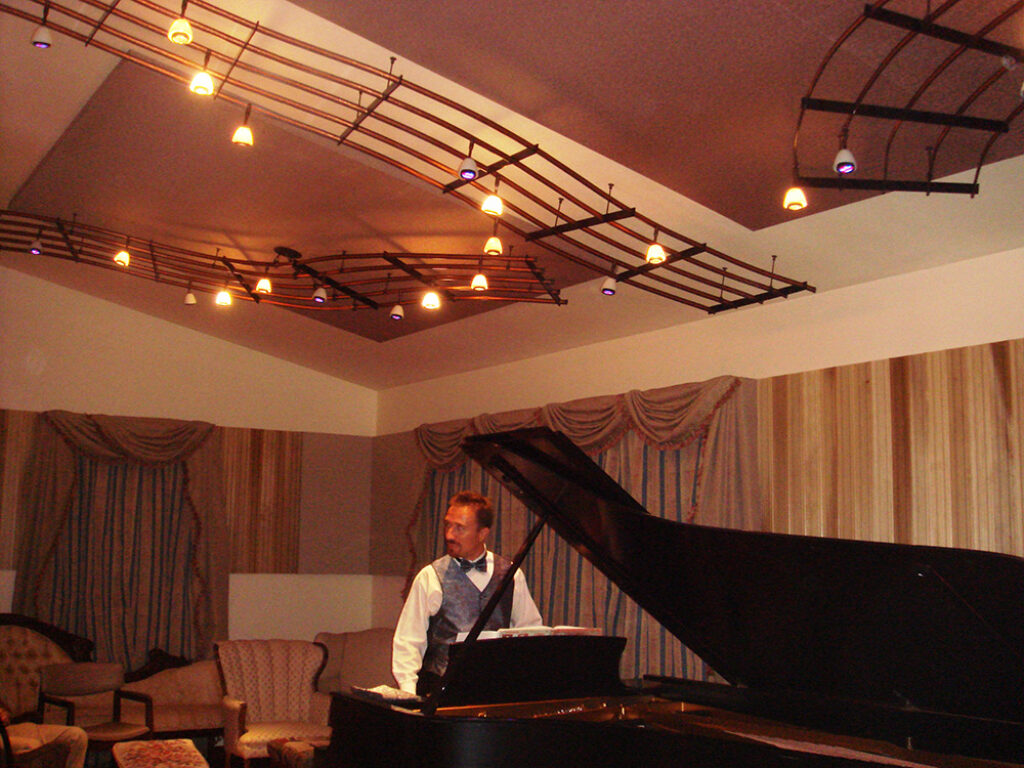 An image of a custom lighting installation that looks like bars of sheet music on the ceiling