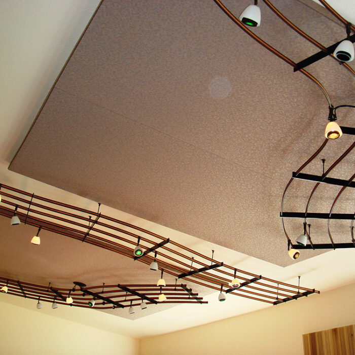 An image of a custom lighting installation that looks like bars of sheet music on the ceiling