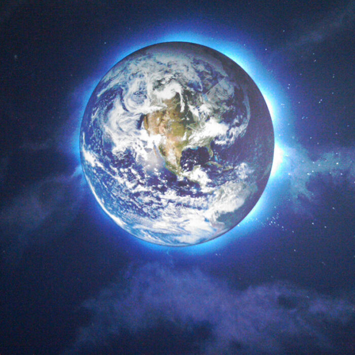 an image of the planet Earth lit from behind on a dark wall of clouds